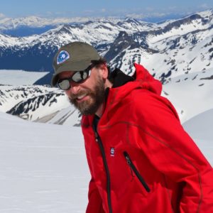 Close up of Eric Steig with a snowy mountainous landscape in the background.