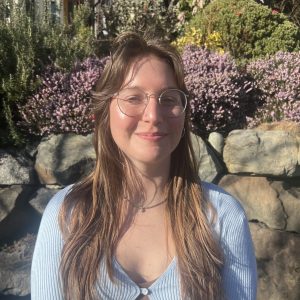 Close up of ESS graduate student Jensen DeGrande in front of flowers.