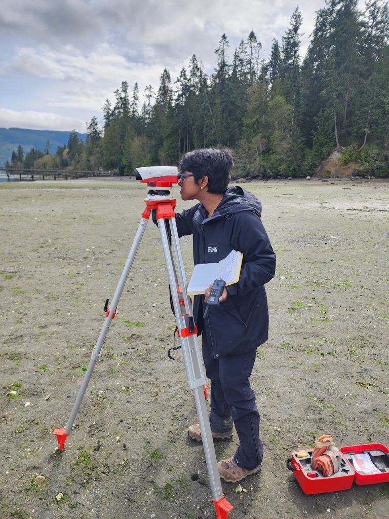 Anjali Manoj looking through field equipment on a beach.