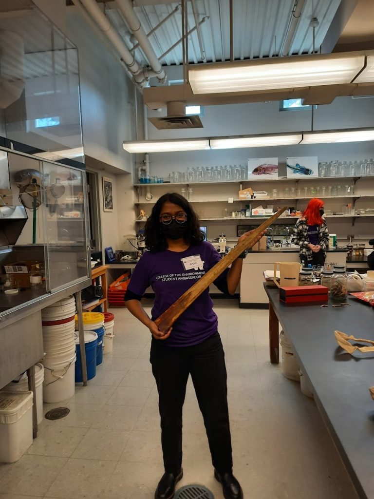 Anjali Manoj holding a large bone in a lab facility.