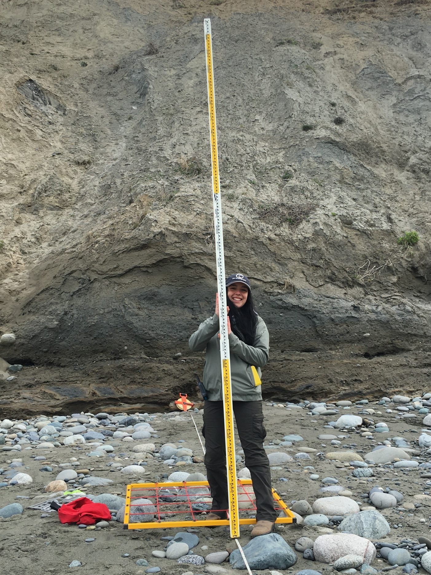Close up of Heather Rose Maran in the field in front of a rock wall.