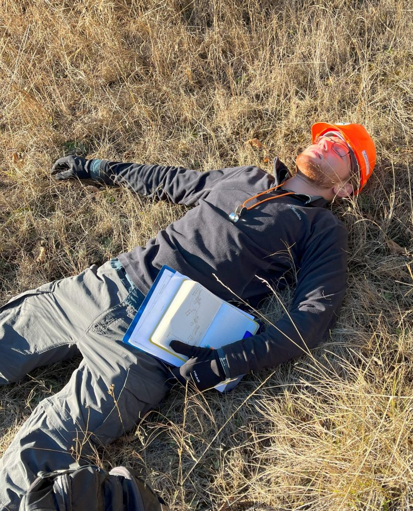 Marquis Richardson in field gear laying on grass.