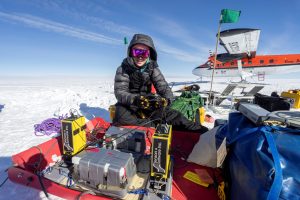 Student Emma Erwin sitting amongst research equipment during a field season in Antarctica.