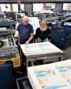 Two employees viewing prints at the Doug Leen Enterprises warehouse.