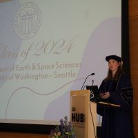 Susannah Morey giving a speech on stage at graduation.