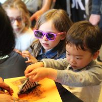 Two young kids stamping paper with a type of fault.