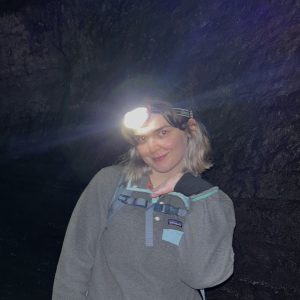 Close up of ESS graduate student Emily Wilbur in the dark wearing a headlamp.