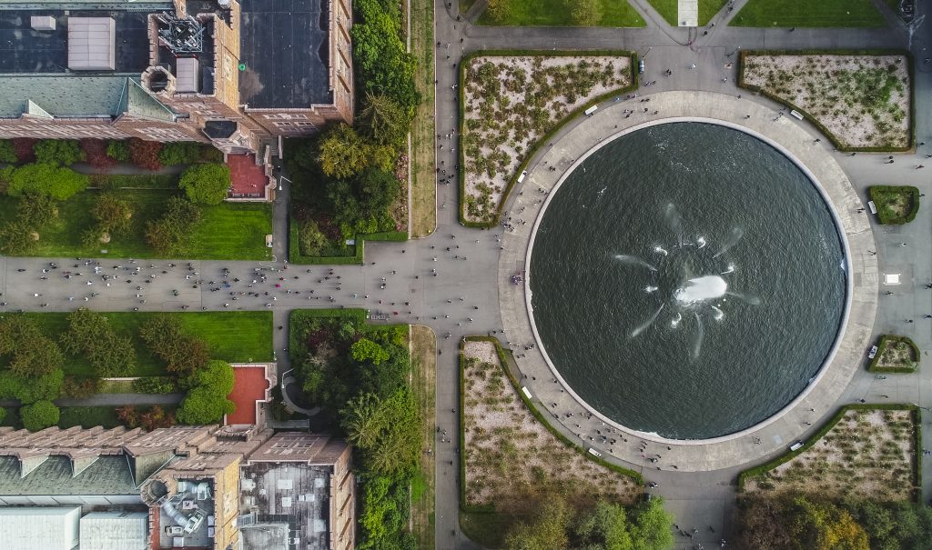 Aerial shot of UW Seattle Campus, Drumheller Fountain with people walking on pathways.