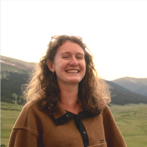 Close up of Zoe Krauss with grass and hills in the background.