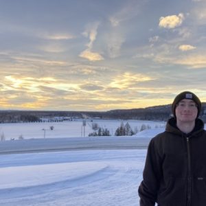 Close up of Andrew Sparks with snowy landscape in the background.