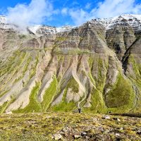 Person hiking with alluvial fans and mountains in the background.