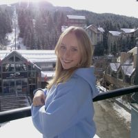 Close up of Ava Hart with a ski slope in the background.