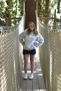 Ava Hart standing on a suspended bridge.
