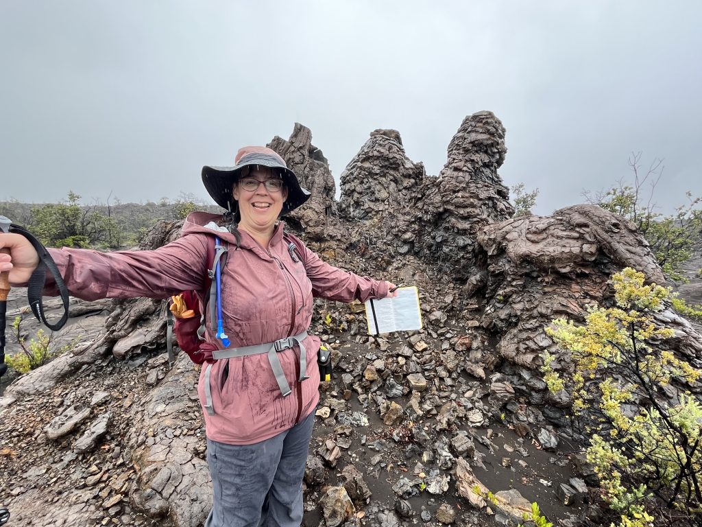 Leigh Tucker in front of a geologic structure called a "Hornito" on Maunaiki, Hawaii.