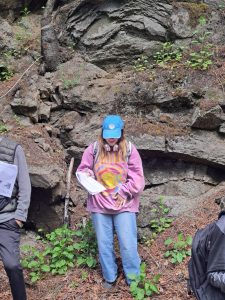 Student Cassandra Embury standing in front of an outcrop.