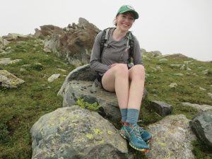 Close up of student Lauren Woods sitting on a boudler.