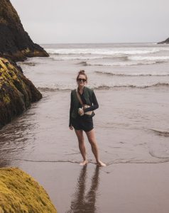 Brielle Herrin standing on a beach with the ocean in the background.
