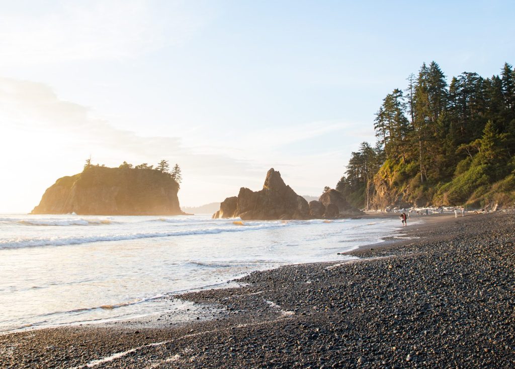 Pacific coast at sunset, waves on a rocky beach.