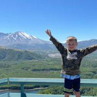 Miles Dimick standing on a platform with Mount St. Helens in the background.