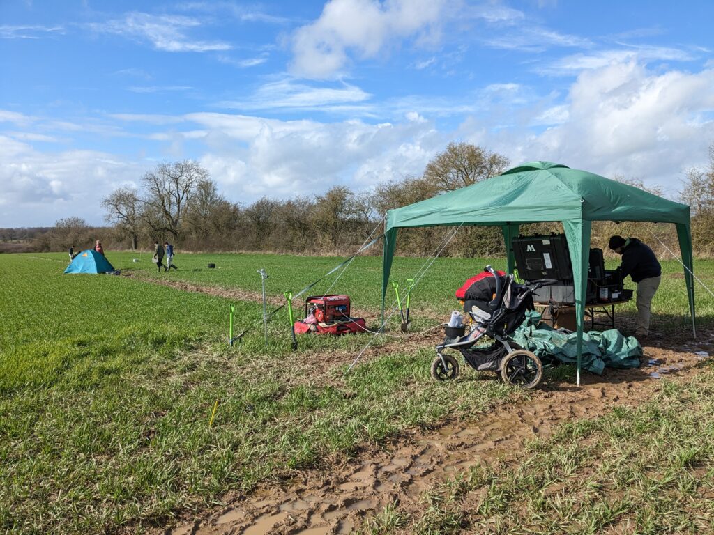 A tent set up on a farming field.