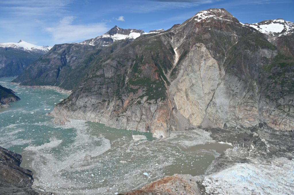 A bare chunk of rock on the hillside adjacent to the water shows where the land slid into the fjord to generate the tsunami.