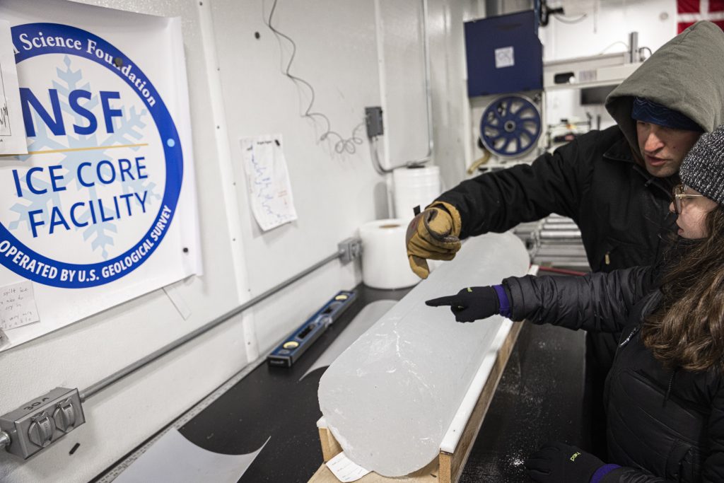 Hailey and Liam look at a specific section of an ice core in the NSF Ice Core Facility.