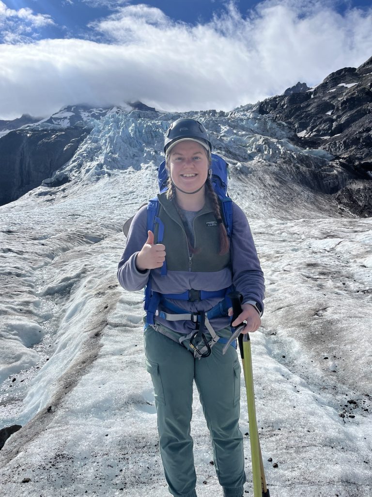 Regan Thomas in climbing gear standing on a glacier on Mount Baker.