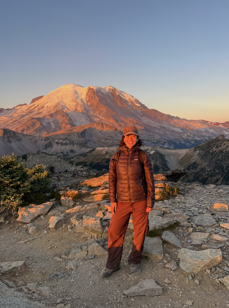 Sofia Suhinin standing in front of a mountain at sunset.