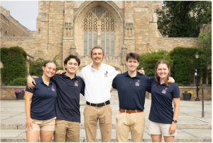 Students Ainsley Morrison, Evan Lee, Addison Selna, Makai Pope and Dahlia Gietka pose in front of a building.