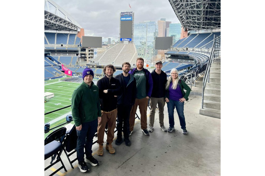PNSN team members pose in the Lumen Stadium stands.