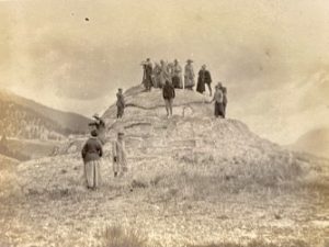 A group of students on top of a rounded rock.