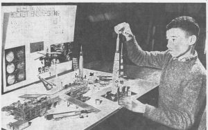 A high school student holding a model rocket.