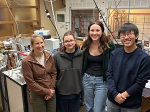 Julia Kelson with three PhD students in a lab.
